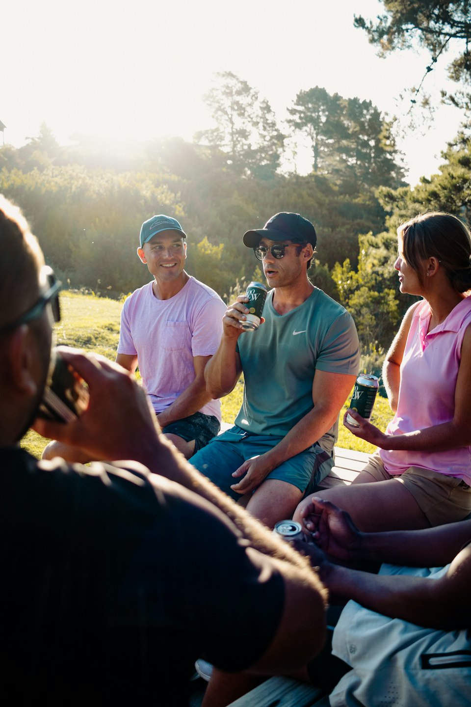 Friends relaxing and chatting outdoors on a sunny day.